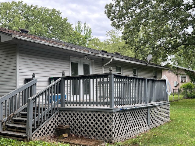 rear view of house featuring a yard, a wooden deck, and fence