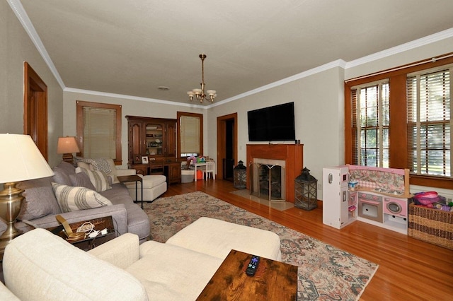 living room with hardwood / wood-style flooring, crown molding, and a chandelier