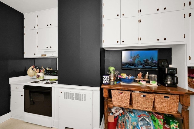 kitchen with electric range and white cabinetry