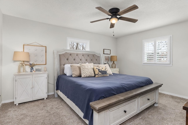 carpeted bedroom featuring ceiling fan and a textured ceiling