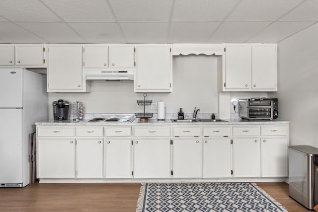 kitchen with dark hardwood / wood-style floors, sink, white cabinets, and white appliances