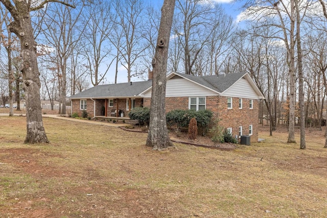 exterior space featuring central AC unit, covered porch, and a front lawn