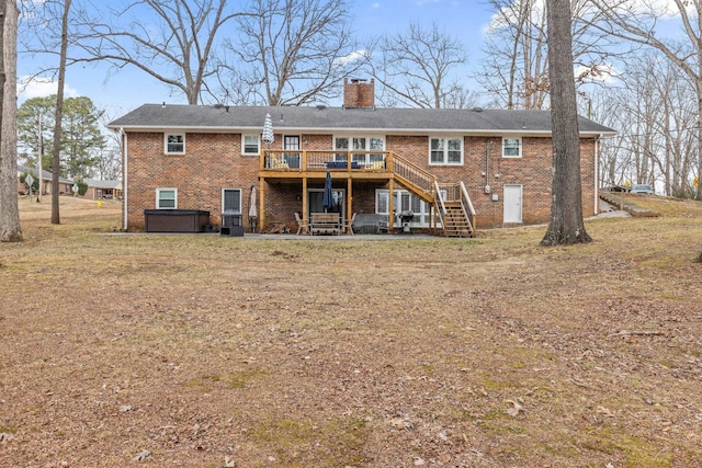 rear view of property with a hot tub, a wooden deck, and a yard