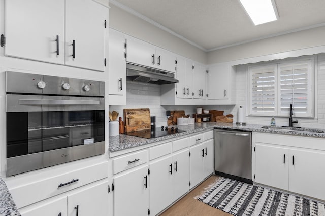 kitchen featuring white cabinetry, stainless steel appliances, sink, and tasteful backsplash