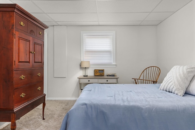 bedroom with light carpet and a drop ceiling