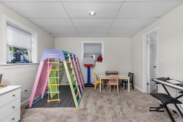 recreation room featuring a paneled ceiling and light colored carpet