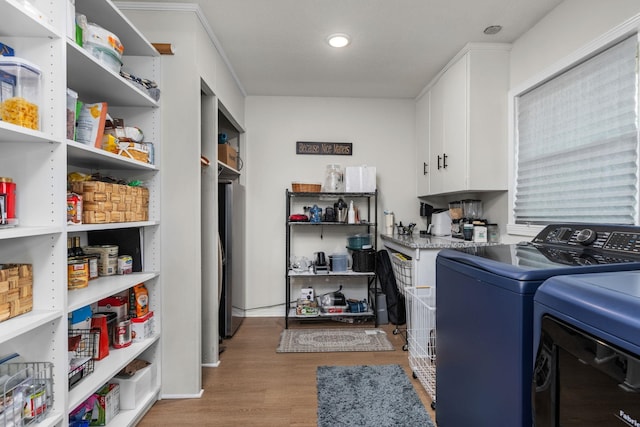 washroom with separate washer and dryer and light hardwood / wood-style flooring