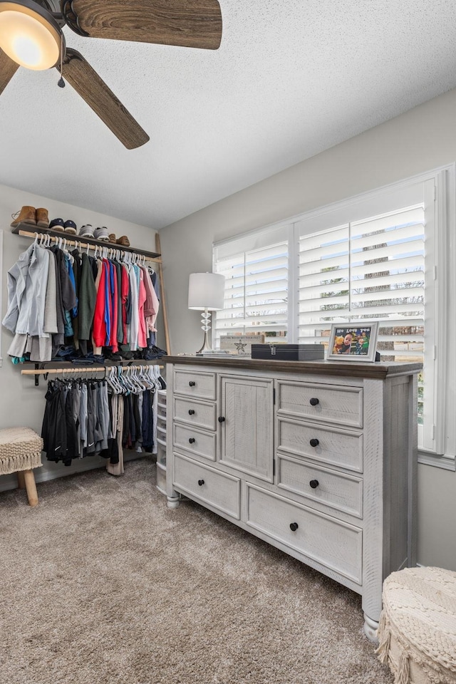 walk in closet with ceiling fan and carpet