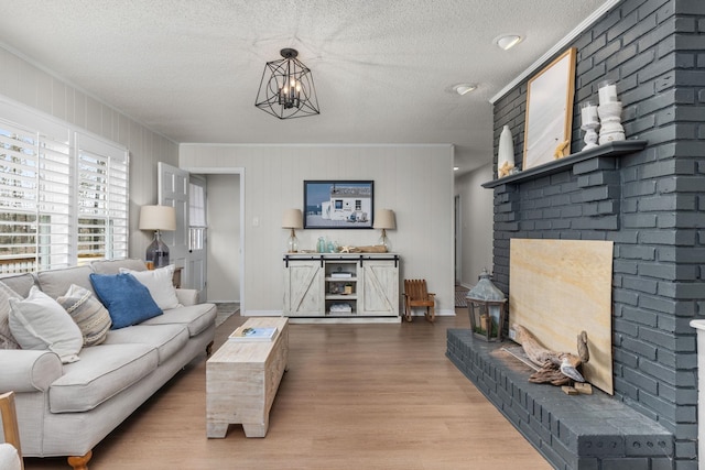 living room with ornamental molding, wood-type flooring, a chandelier, and a textured ceiling