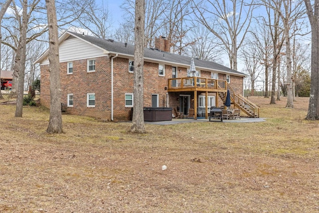 rear view of property featuring a hot tub, a wooden deck, and a patio