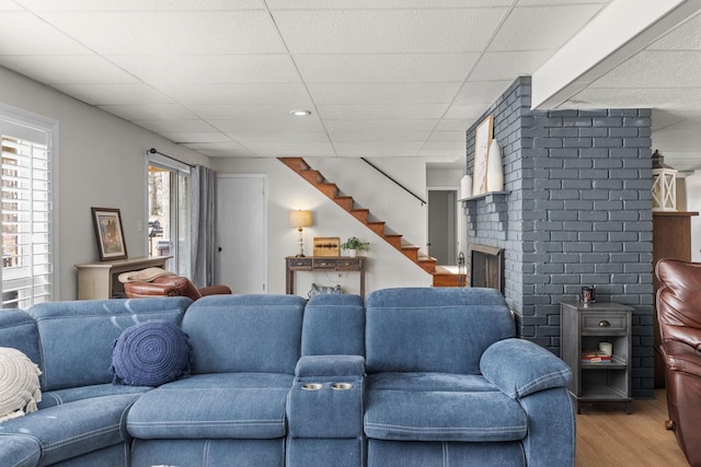 living room with a drop ceiling and hardwood / wood-style flooring