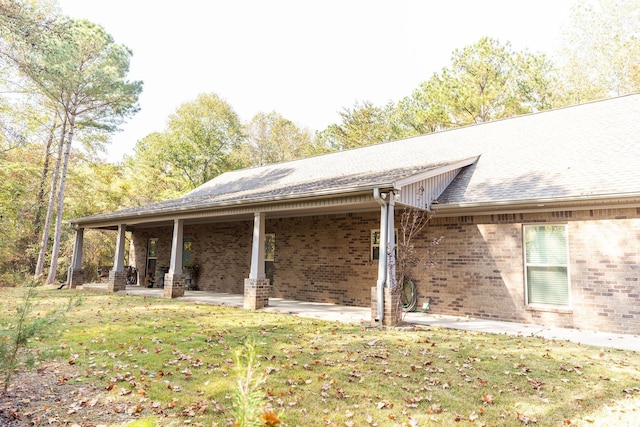 rear view of house with a lawn and a patio