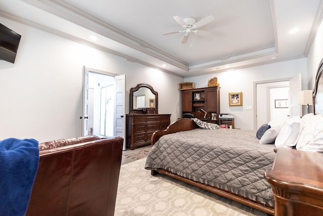 bedroom with ceiling fan, light colored carpet, crown molding, and a tray ceiling