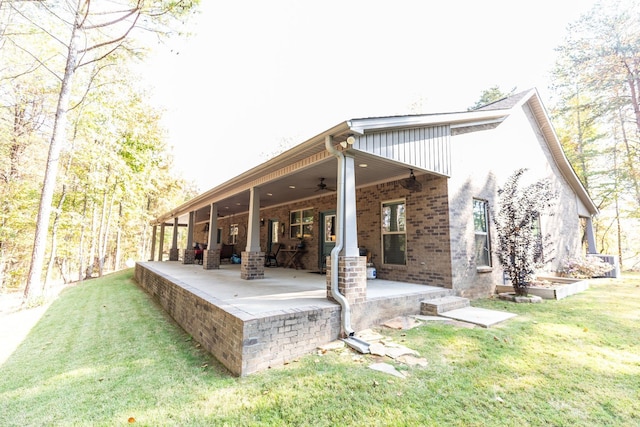 back of property with a yard, a patio, and ceiling fan