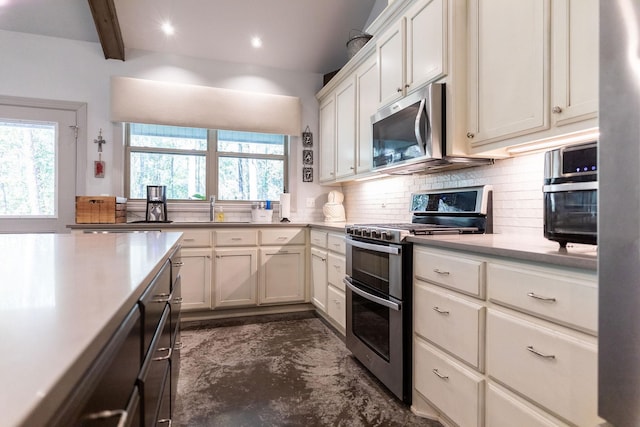 kitchen with backsplash, white cabinets, a wealth of natural light, beamed ceiling, and stainless steel appliances