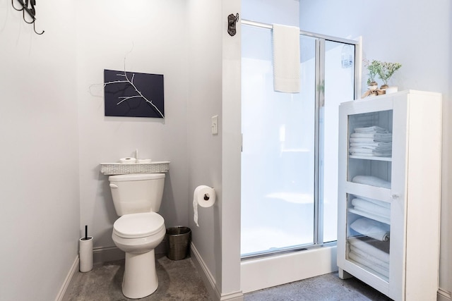 bathroom with a shower with door and toilet