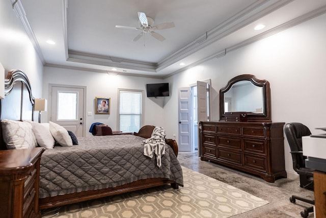 bedroom featuring a tray ceiling, crown molding, ceiling fan, and light colored carpet