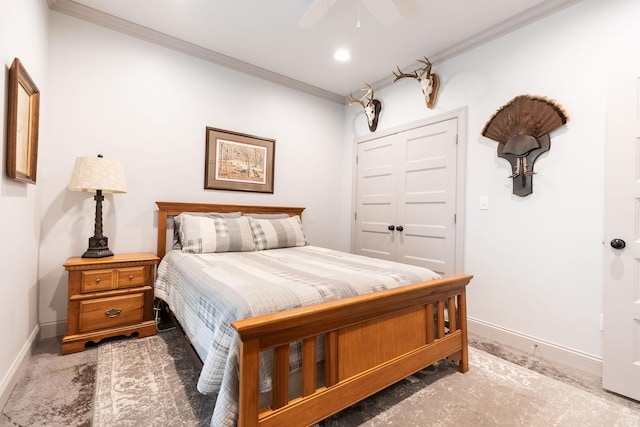 carpeted bedroom with ceiling fan, crown molding, and a closet