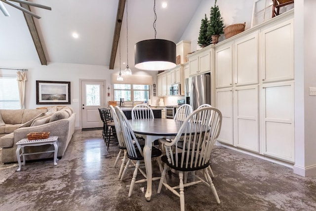 dining area featuring beam ceiling and high vaulted ceiling