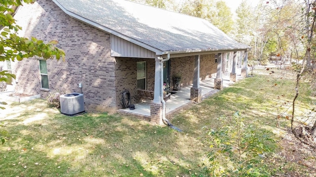 exterior space with a lawn, a patio area, and central air condition unit