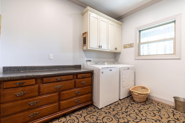 clothes washing area featuring cabinets, ornamental molding, and washing machine and dryer