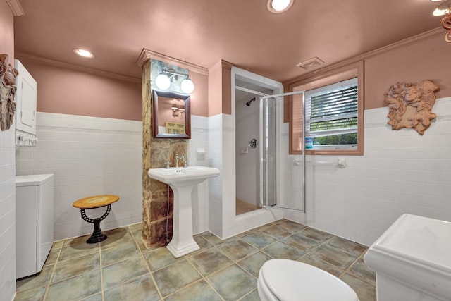 bathroom with a shower with door, toilet, tile walls, and ornamental molding