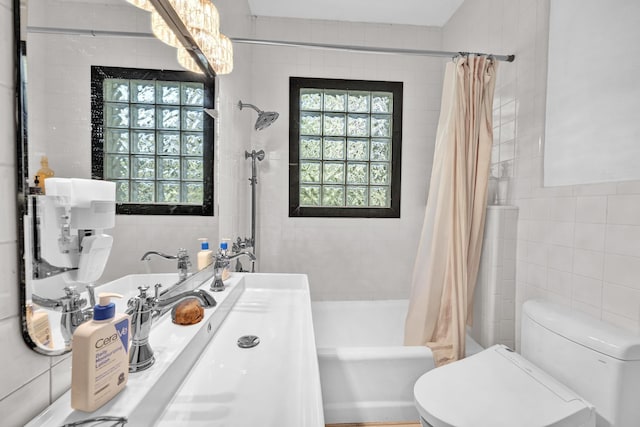 full bathroom with toilet, shower / tub combo with curtain, tile walls, and sink