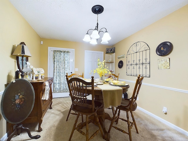 carpeted dining room with a textured ceiling and an inviting chandelier