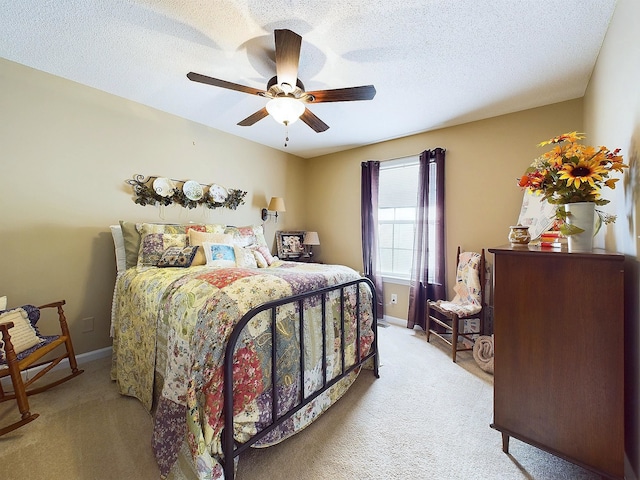 carpeted bedroom featuring ceiling fan and a textured ceiling