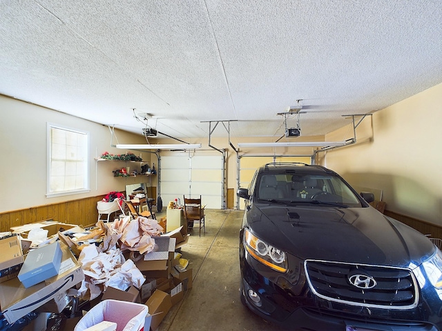 garage with a garage door opener and wooden walls