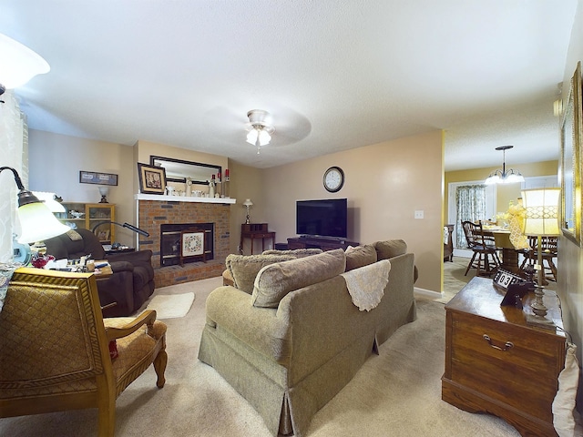 living room featuring ceiling fan with notable chandelier, light carpet, and a fireplace