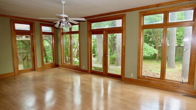  - unfurnished sunroom with french doors, wood finished floors, and baseboards