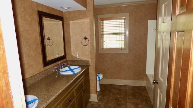  - bathroom with double vanity, a bath, baseboards, toilet, and tile patterned flooring