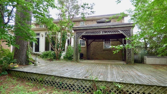  - rear view of house featuring a gazebo, brick siding, and a wooden deck