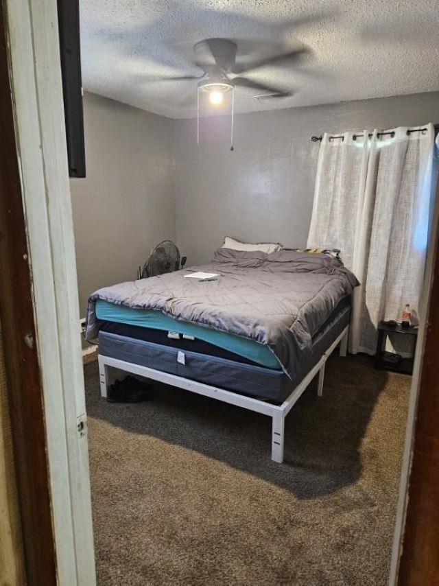  - bedroom with carpet, a textured ceiling, and a ceiling fan