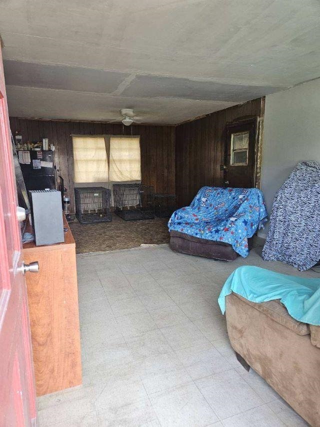 - living area with wood walls and tile patterned floors