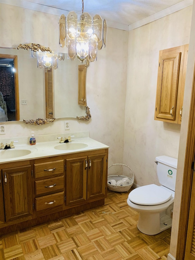 bathroom featuring vanity, ornamental molding, parquet floors, and toilet