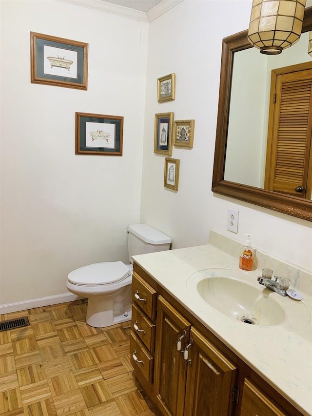 bathroom featuring vanity, parquet flooring, ornamental molding, and toilet