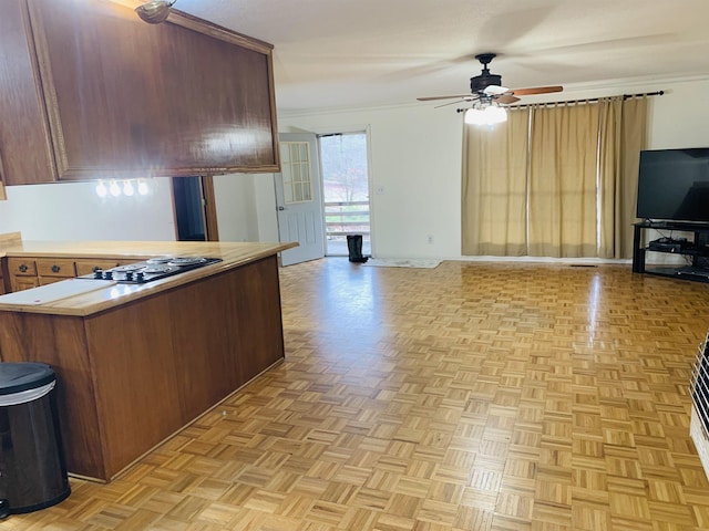 kitchen with ornamental molding, ceiling fan, kitchen peninsula, light parquet flooring, and black electric cooktop