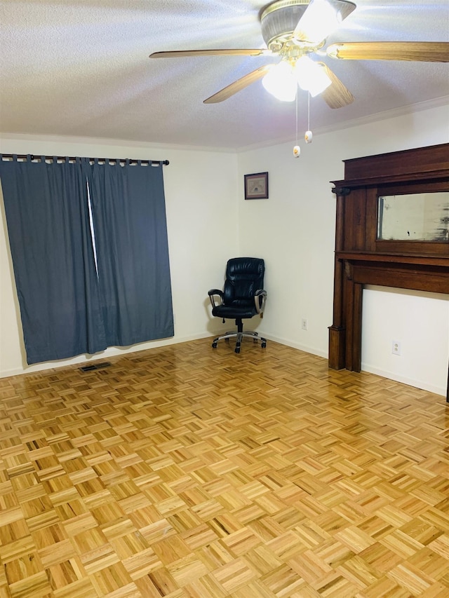 unfurnished office featuring light parquet flooring, ceiling fan, and a textured ceiling