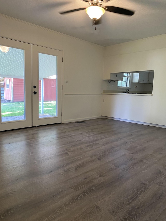  - unfurnished living room with plenty of natural light, french doors, dark wood finished floors, and a ceiling fan