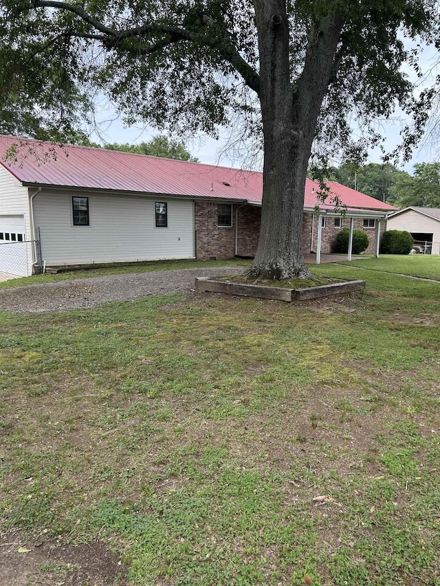  - view of front of property featuring a front lawn, metal roof, and a garage