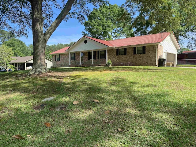 - ranch-style home featuring a front yard, metal roof, an attached garage, and brick siding