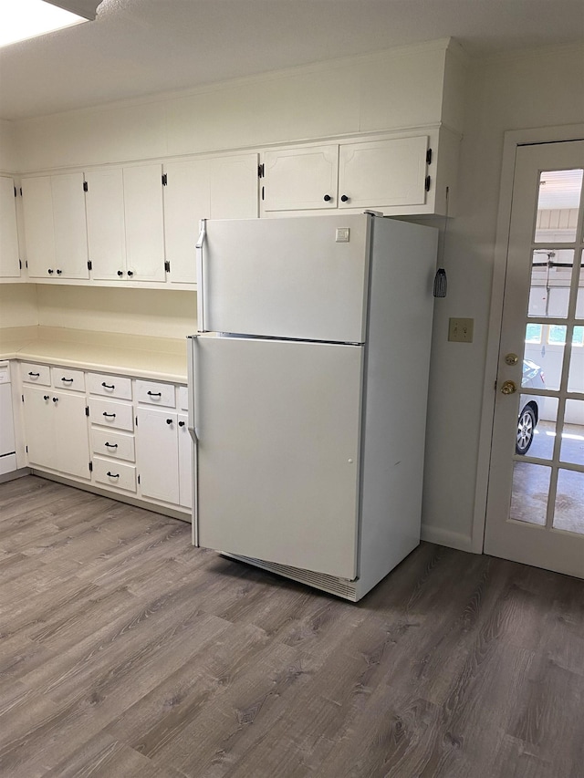  - kitchen featuring freestanding refrigerator, white cabinetry, and wood finished floors
