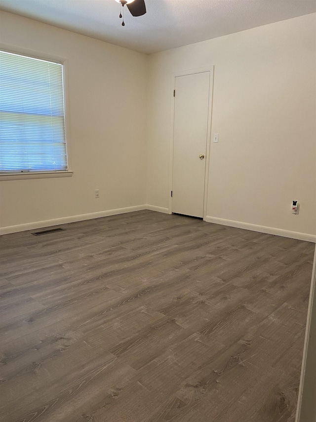  - spare room with dark wood finished floors, baseboards, and a ceiling fan