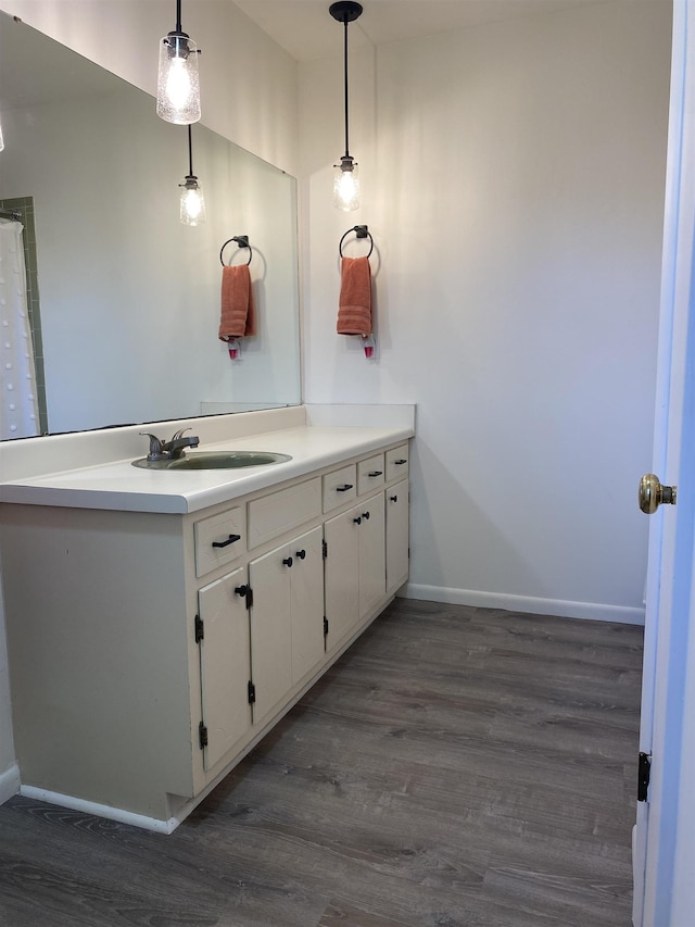  - bathroom with wood finished floors, baseboards, and vanity