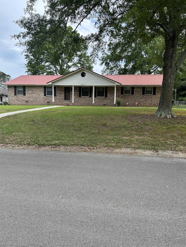  - single story home with a front lawn, brick siding, and metal roof
