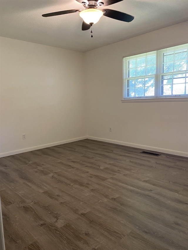  - unfurnished room featuring plenty of natural light, dark wood-type flooring, baseboards, and a ceiling fan