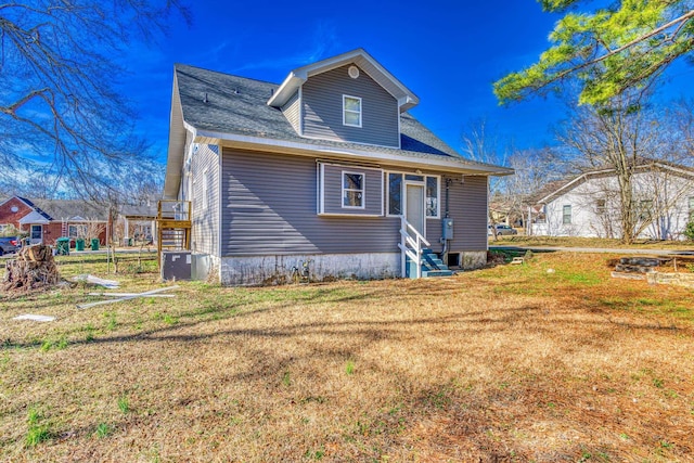 view of front of property with a front yard and central AC unit