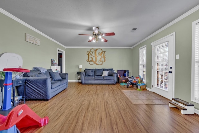  - living room featuring wood finished floors, ornamental molding, and a ceiling fan